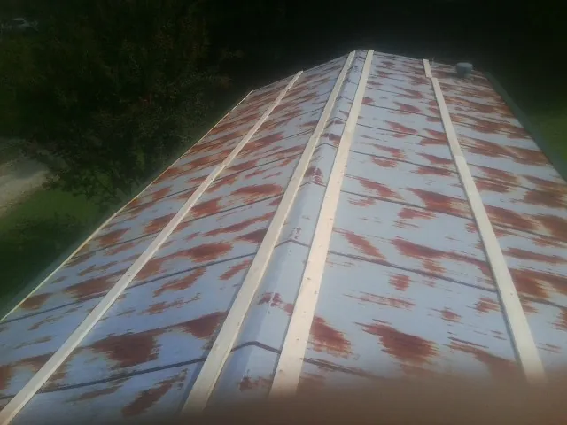 Rusted metal roof panels with new wood purlins before replacement — Storm Damage Roof Repair in North Canton by Roofing Brothers