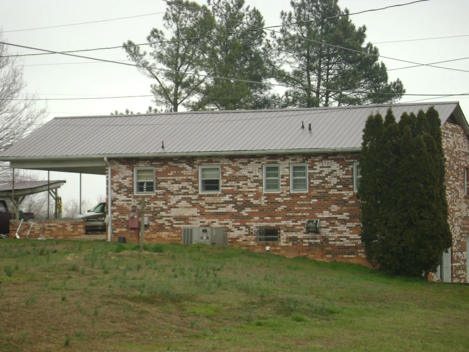 Gray metal roof on a brick split level home with a carport in North Canton